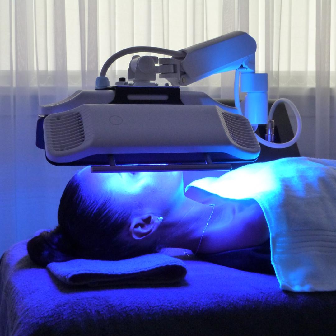 Client receiving Dermalux LED blue light phototherapy at Village Aesthetics in Wimbledon Village